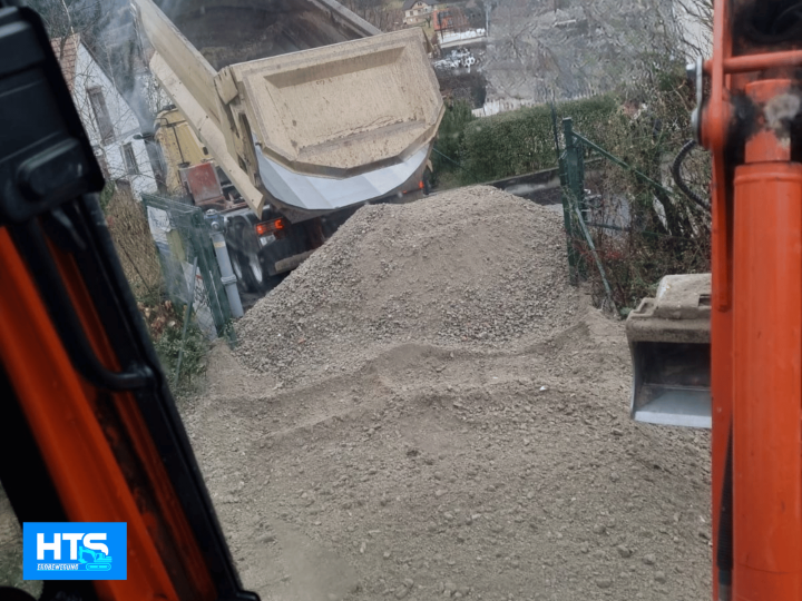 Materiallieferung für Erdarbeiten mit LKW-Kipper und Minibagger von HTS Erdbewegung. Anlieferung von Schotter für Wegebau, Unterbau, Zufahrt und Flächenbefestigung im Privatgarten und Außenbereich.