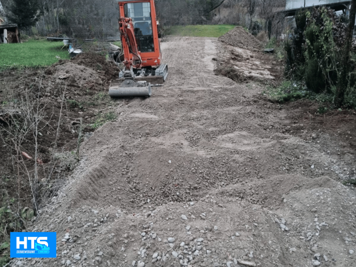 Baggerarbeiten mit Minibagger auf einer privaten Zufahrtsfläche. HTS Erdbewegung beim Herstellen eines tragfähigen Unterbaus, Planieren, Schottereinbau, Geländeausgleich und Vorbereitung für spätere Befestigungsarbeiten.