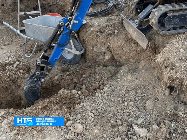 HTS Erdbewegung beim Ausheben einer Künette mit Minibagger in einem engen Arbeitsbereich für Leitungen und Versorgungsanschlüsse.