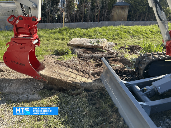 Minibagger von HTS Erdbewegung beim Entfernen einer bestehenden Betonplatte als Vorbereitung für den Poolaushub in einem Privatgarten.