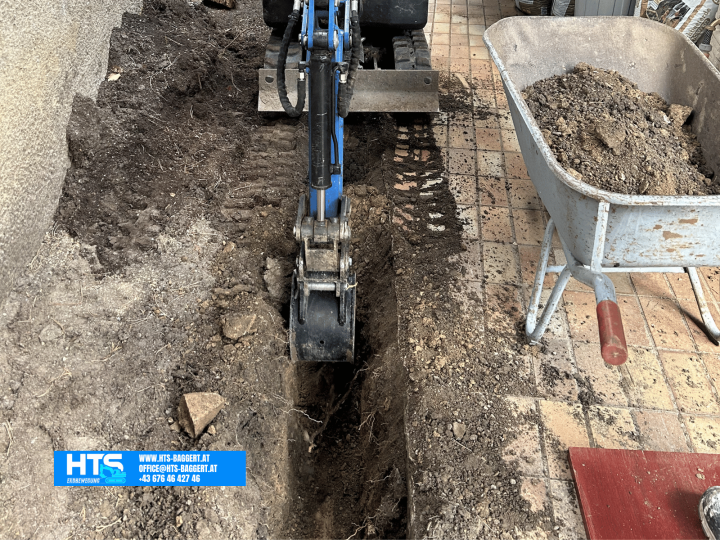 Schmale Künette in einem schwer zugänglichen Gartenbereich, ausgehoben mit einem kompakten Minibagger von HTS Erdbewegung.