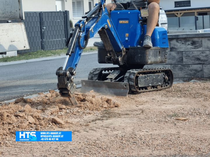 Minibagger mit Reißzahn beim Aufbrechen eines durch Befahren extrem stark verdichteten Pflasterunterbaus